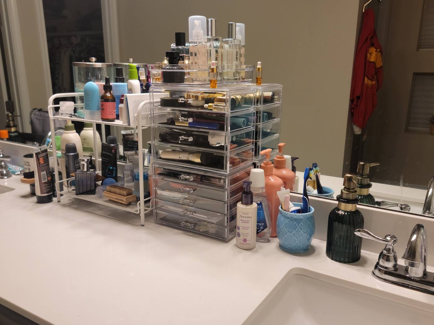 A bathroom vanity covered with cosmetics and brushes, then the same vanity with products in tiered acrylic storage