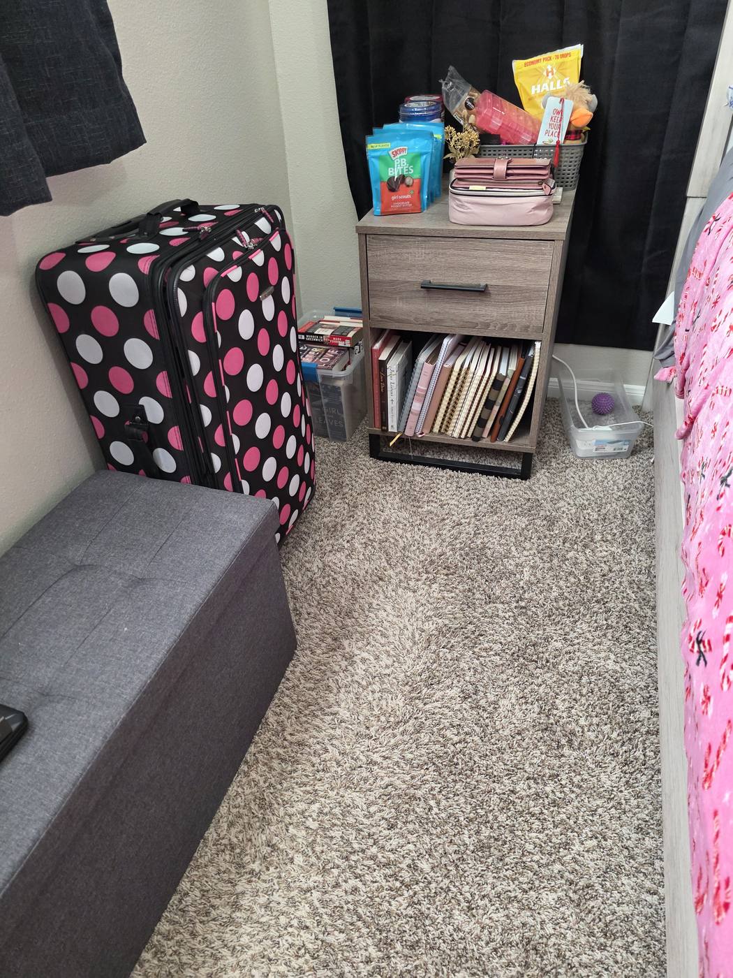 A bedroom corner filled with bins, bags and loose items, then the same corner with a bench, a nightstand and clear floor