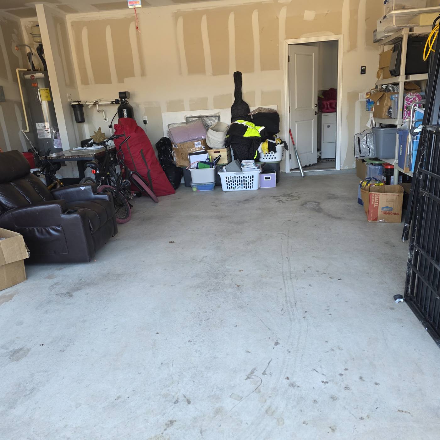 A garage floor packed with furniture, bikes and boxes, then the same garage cleared with an open floor