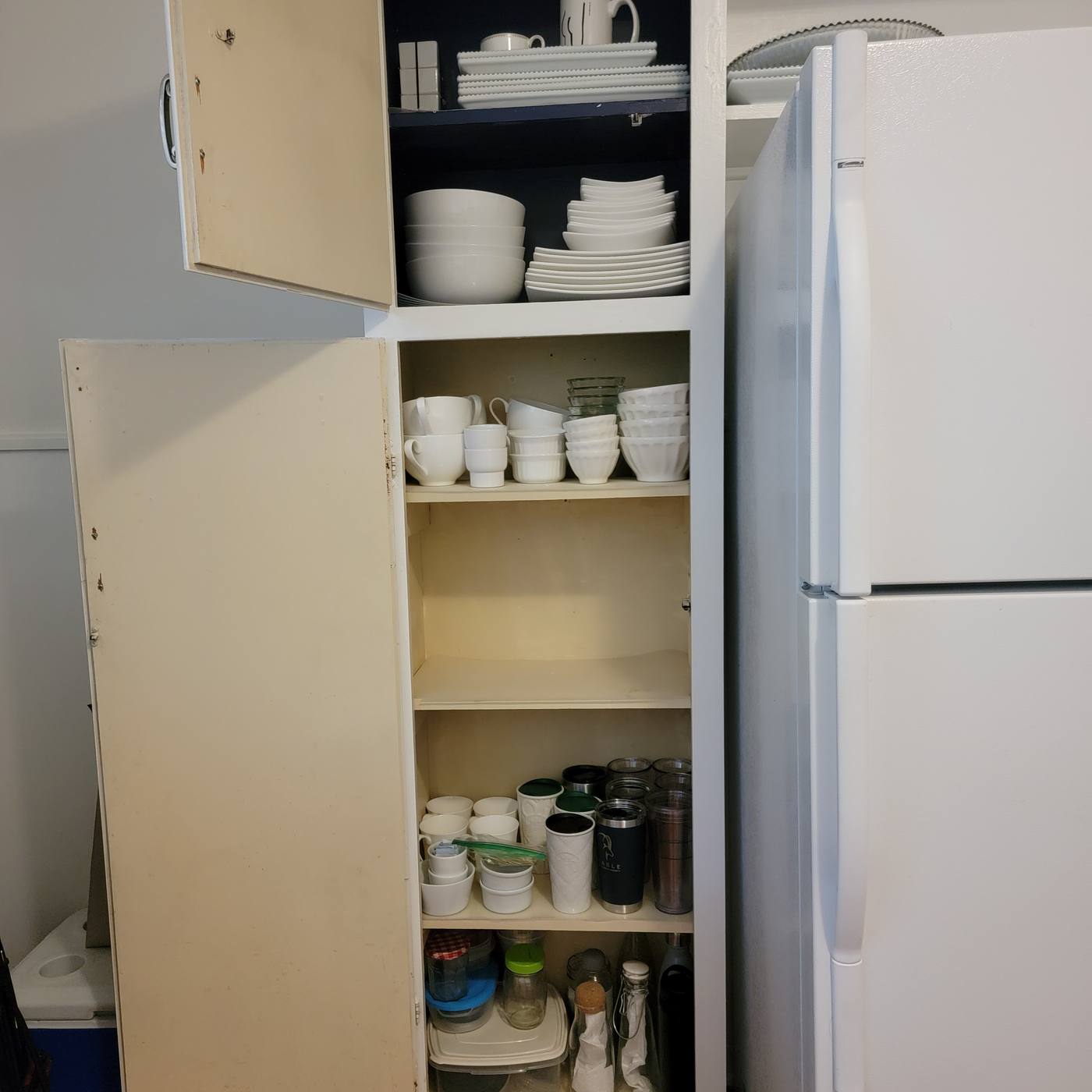 An empty kitchen cabinet mid-move, then the same cabinet unpacked with dishes and glassware arranged by use