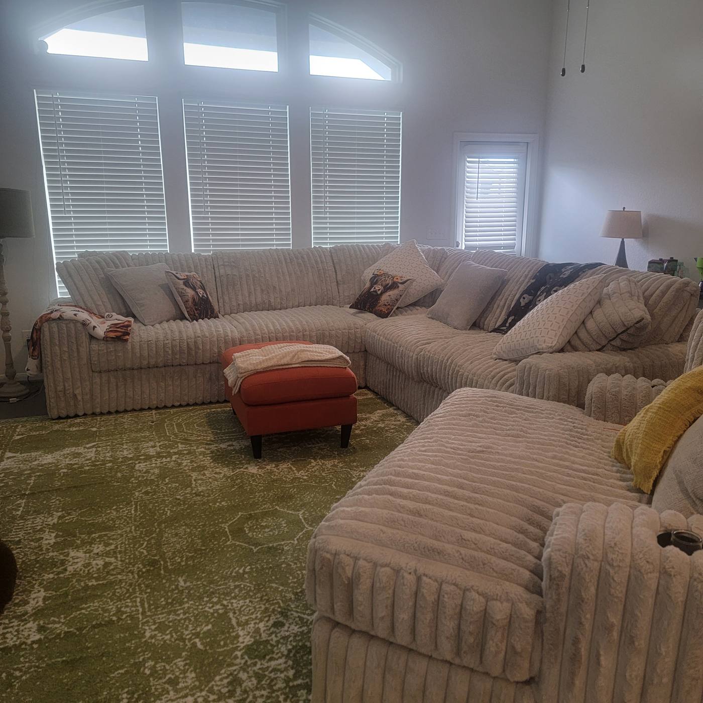 A sectional sofa buried under clothing and household items, then the same sofa cleared and ready to sit on