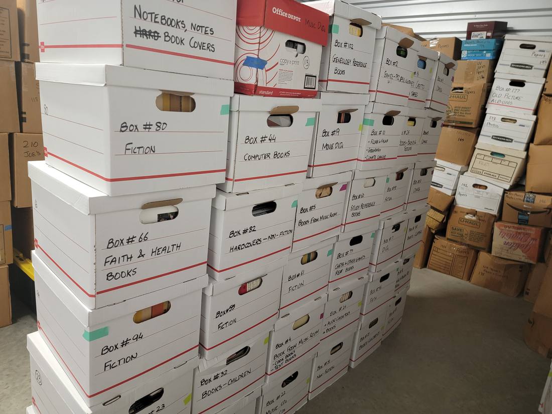 Numbered and labeled boxes stacked in rows inside a storage unit