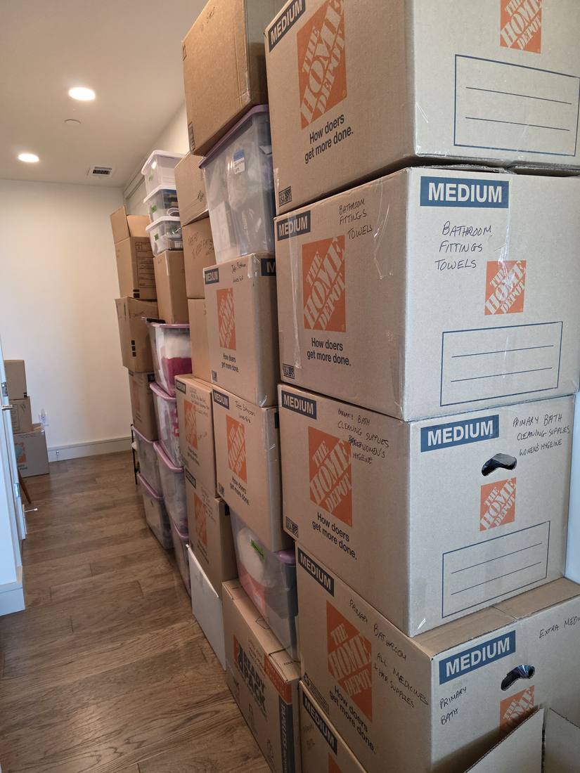 A stack of moving boxes with contents written on each one