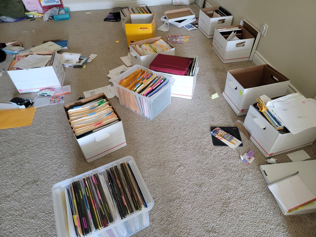 Paperwork spread out and sorted into file boxes on the floor