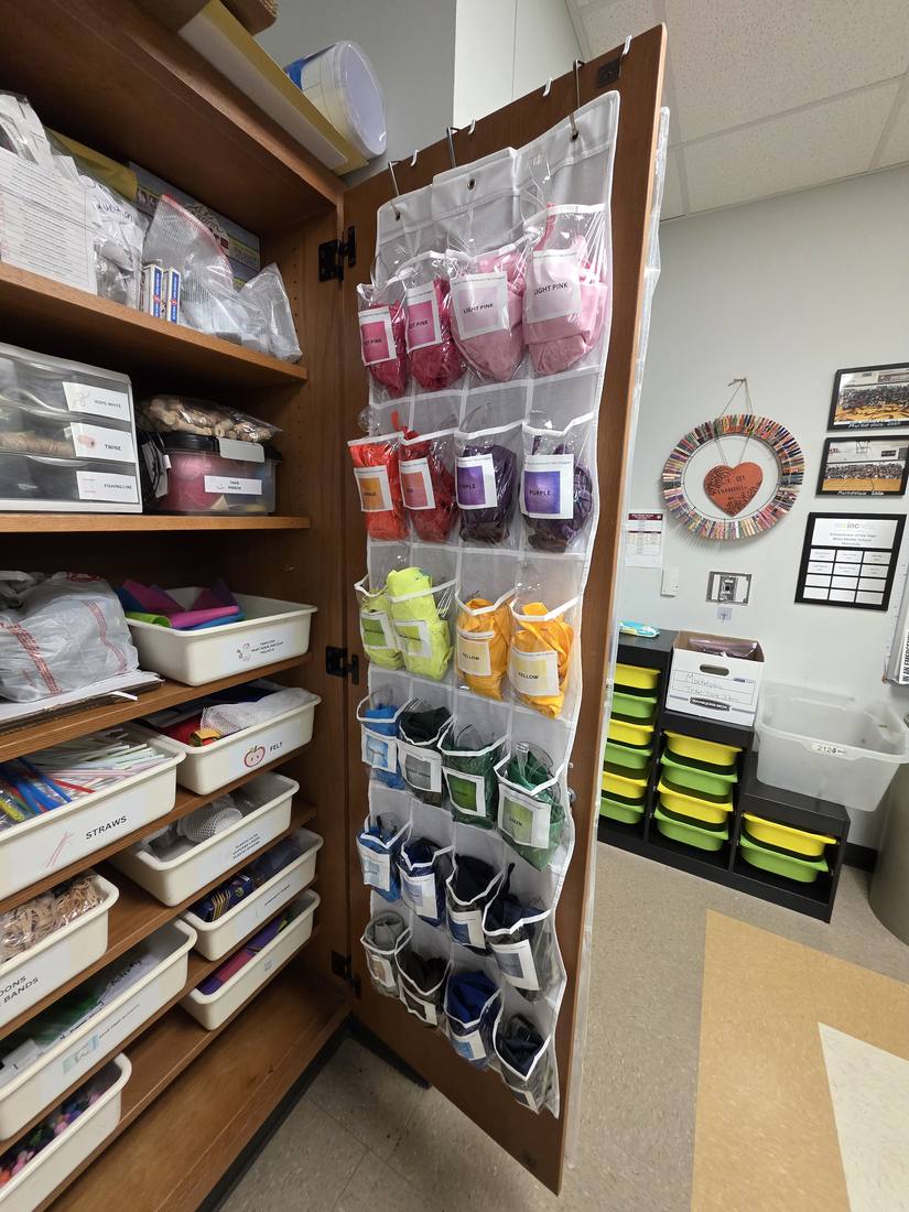 An over-the-door organizer holding classroom supplies in clear pockets